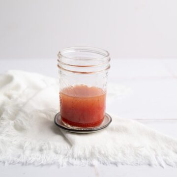 a mason jar with Strawberry Vinaigrette on a table.