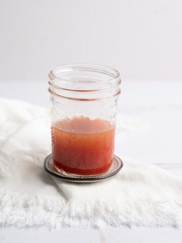 a mason jar with Strawberry Vinaigrette on a table.