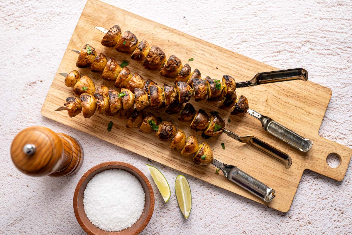 marinated baby potatoes on skewers on a wooden board.