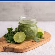 small mason jar filled with cilantro lime marinade on a wooden board.