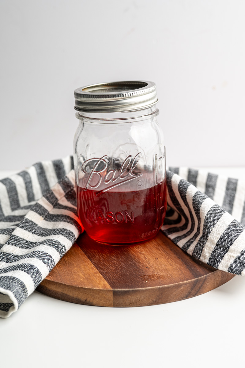 mason jar filled with strawberry infused vinegar. 