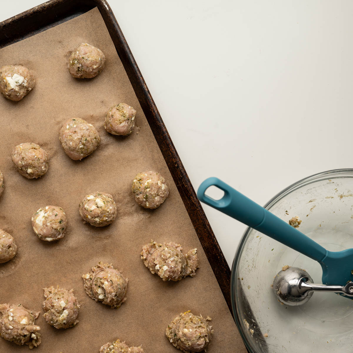 half rolled and half divided out chicken meatballs.