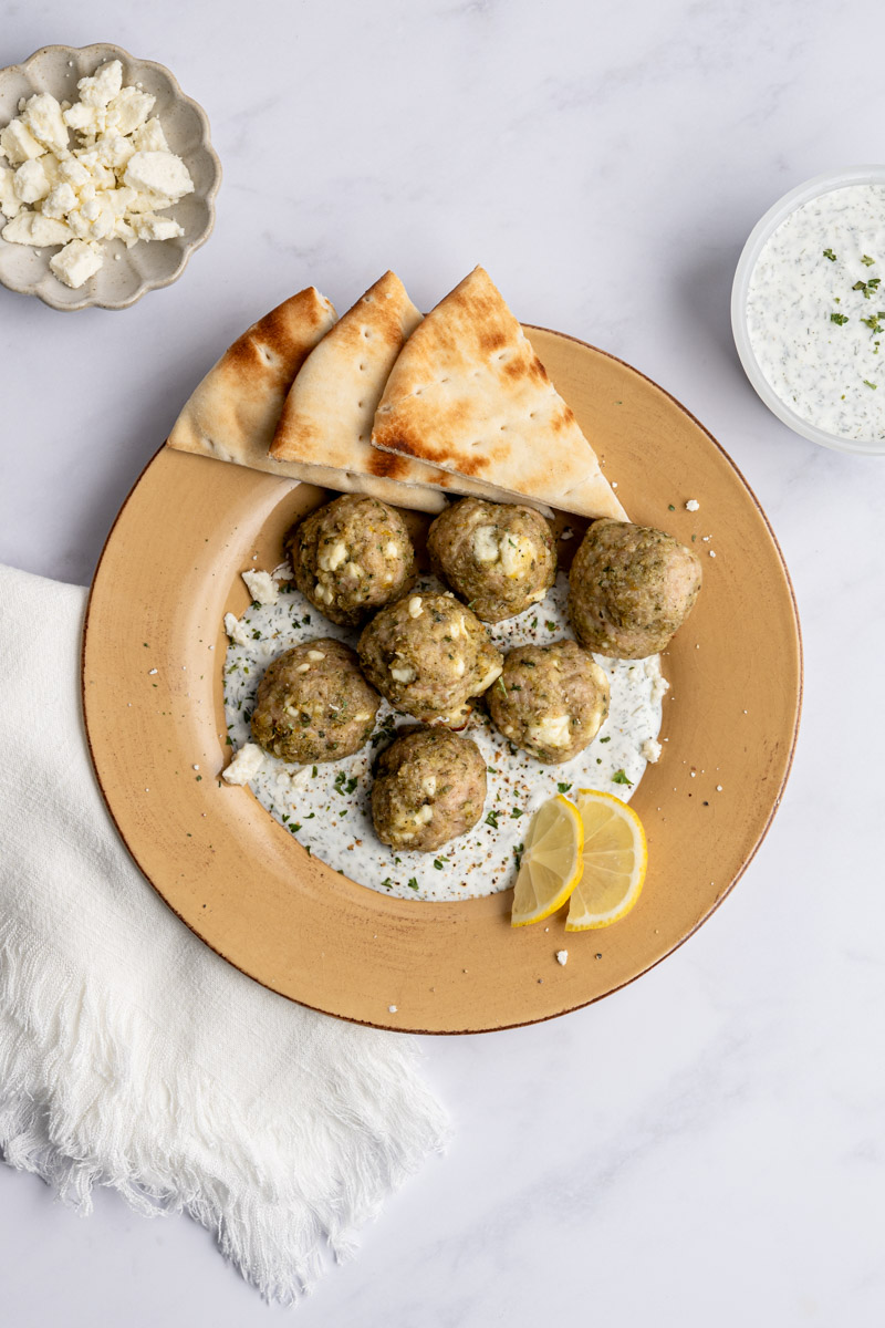 greek chicken meatballs on lemon yogurt sauce and pitas.