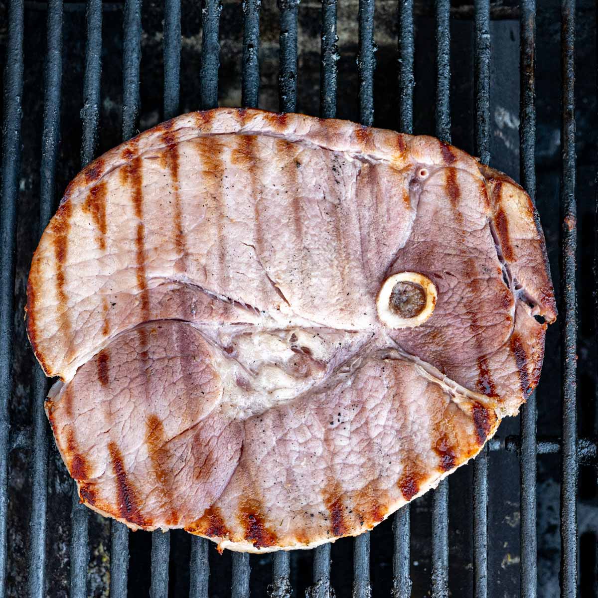 ham steak on a grill with grill marks.