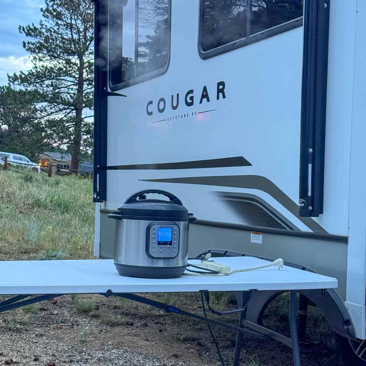 instant pot sitting on a white table in front of a camper.