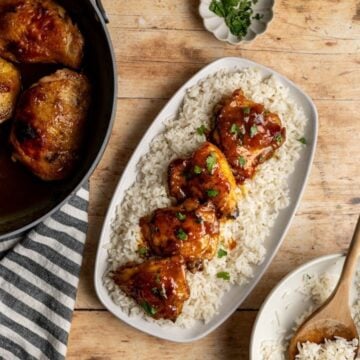 four pieces of baked chicken thighs with apricot curry sauce on a bed of coconut rice.