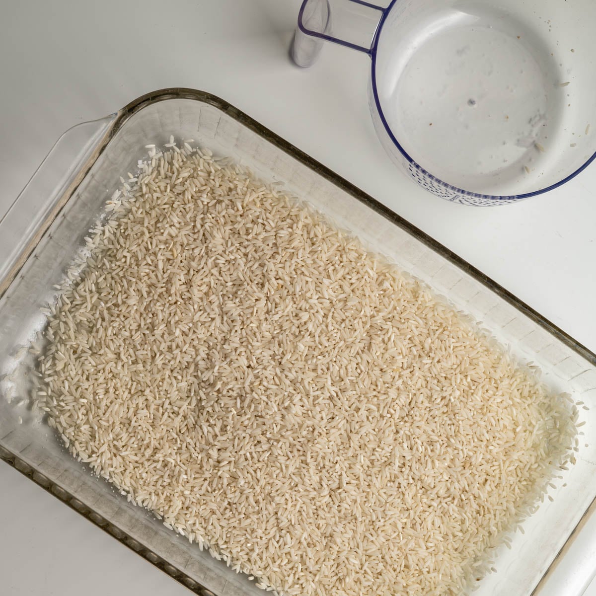 glass 9x13 inch baking pan with uncooked rice.