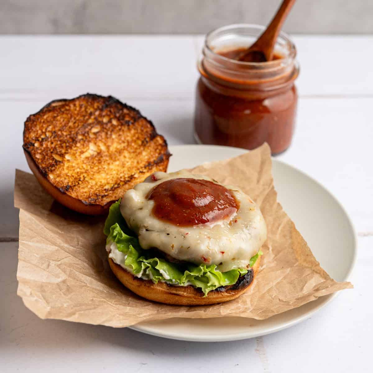 bloody mary burger topped with bloody mary ketchup on a plate.