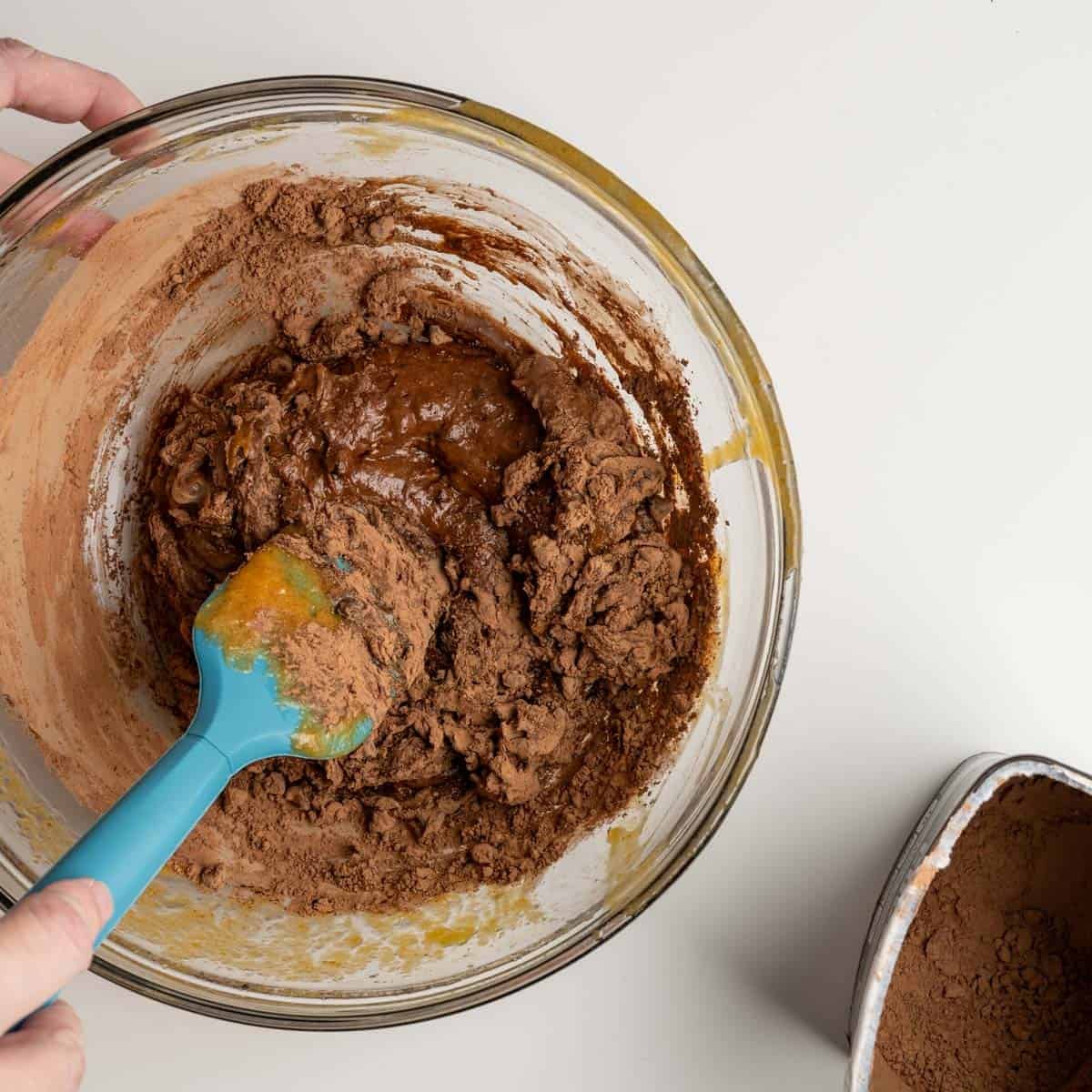 chocolate swirl batter mixing with a blue spatula.
