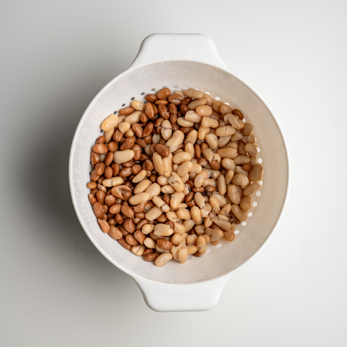 canned beans drained and rinsed in a white colander.