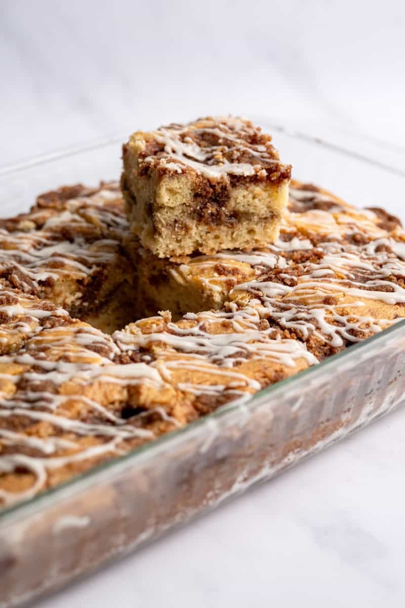 baked cinnamon coffee cake with a piece cut out of the middle to show the layers.
