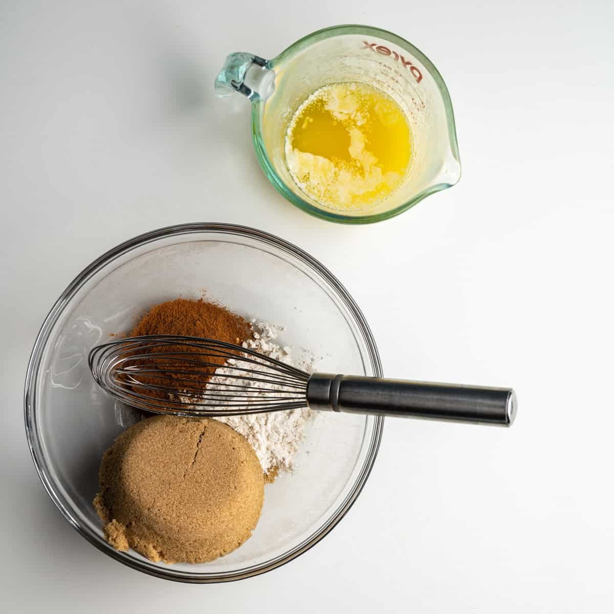 struesel ingredients in a glass bowl alongside melted butter.