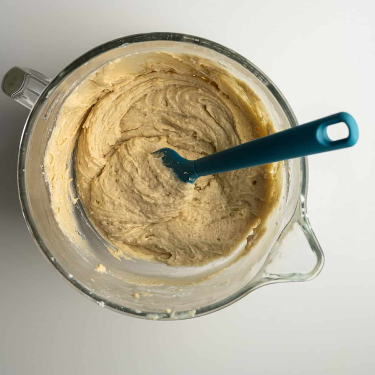 cake batter mixed together with a blue spatula.