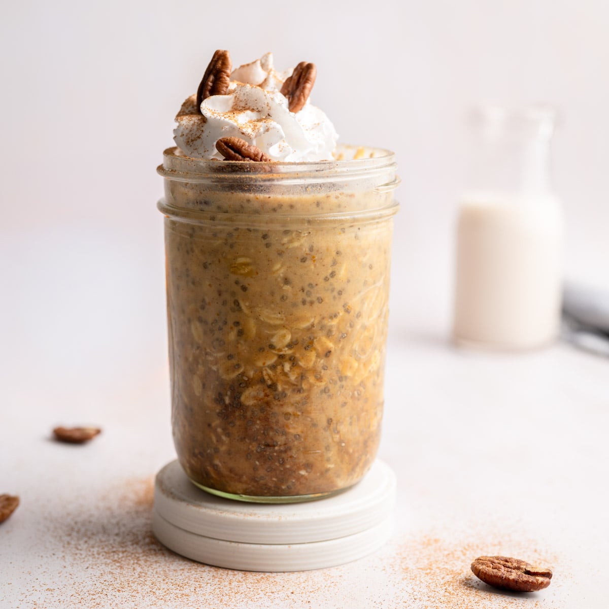 soaked overnight oats topped with coconut whipped cream, cinnamon and pecans.
