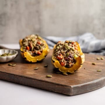 two delicata squash halves, stuffed with quinoa vegetable stuffing.