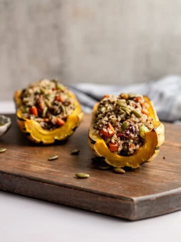 two delicata squash halves, stuffed with quinoa vegetable stuffing.