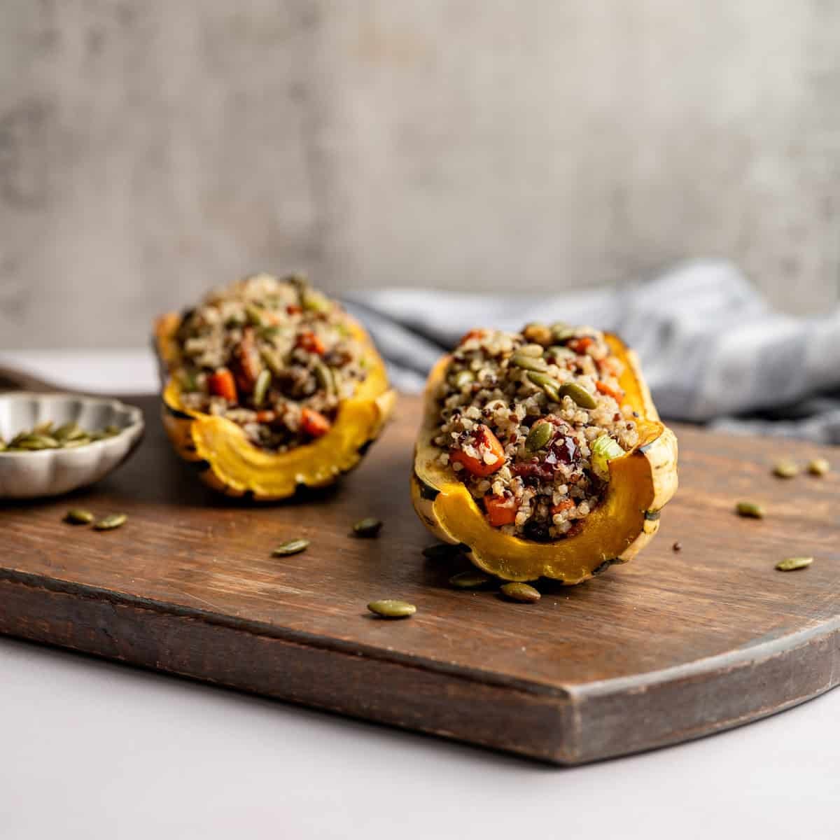 two delicata squash halves, stuffed with quinoa  vegetable stuffing. 