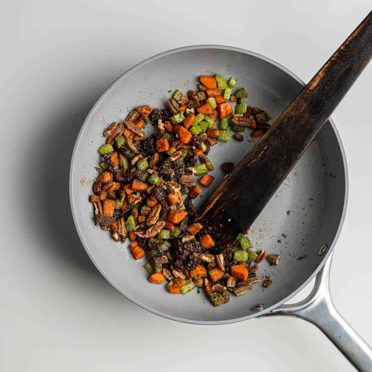 skillet with chopped vegetables, spices, pecans and cranberries.