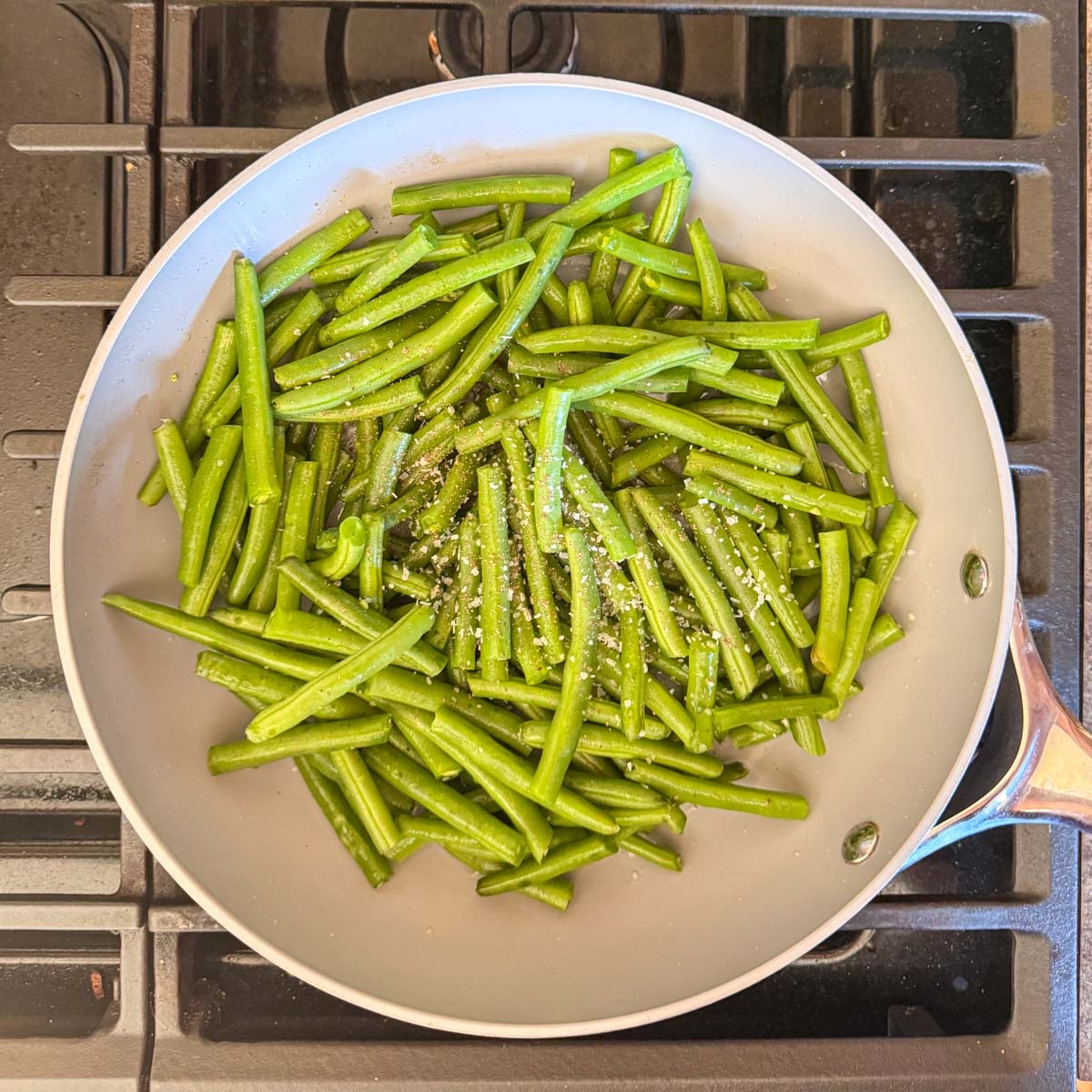 fresh green beans in a skillet on a stovetop.