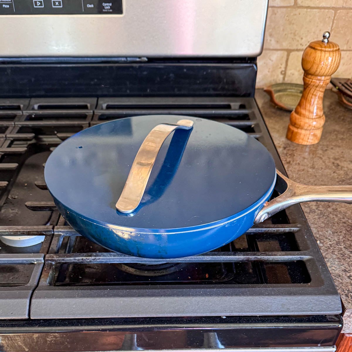covered skillet while green beans steam with water.